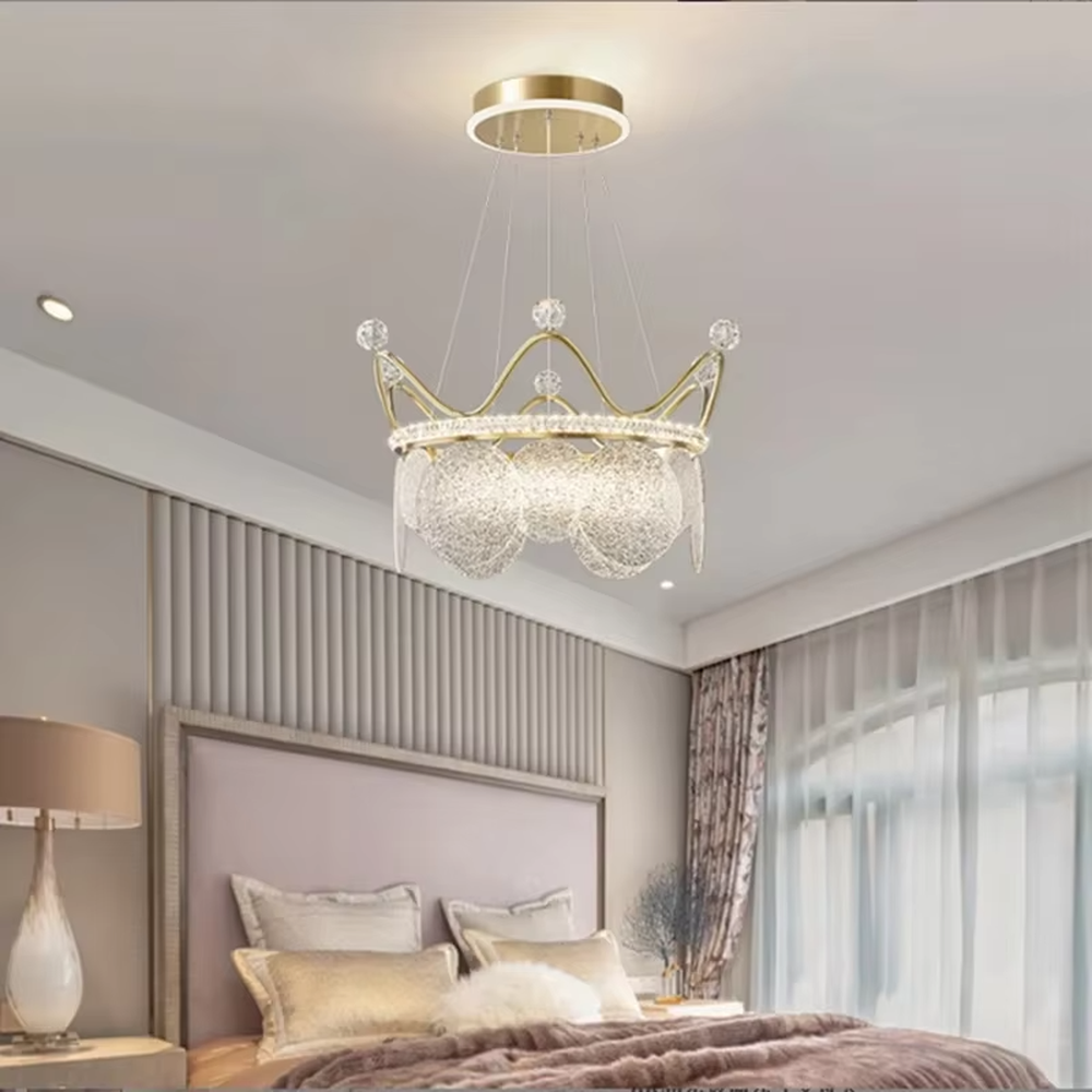 A light luxury princess-style crown-shaped chandelier, featuring a gold metal crown frame paired with crystal decorations and glowing glass lampshades. It emits a brilliant yet soft glow when lit, combining decorative appeal with practical illumination, ideal for creating a romantic and dreamy space atmosphere.