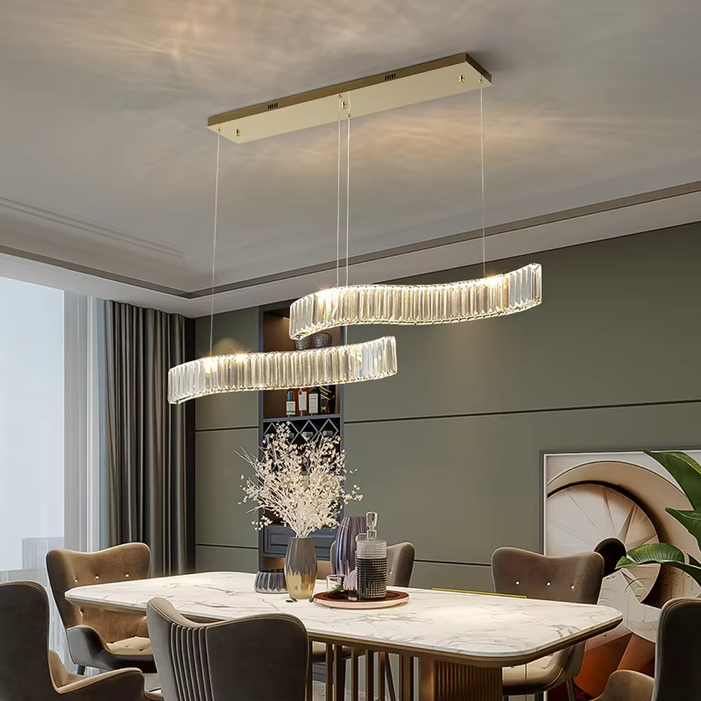 This modern light luxury linear chandelier features a gold metal ceiling plate, paired with faceted crystal strips to create an irregular undulating shape. Light refracts through the crystals to emit a brilliant glow, serving both lighting and decorative purposes, suitable for modern light luxury spaces such as dining rooms and bars.