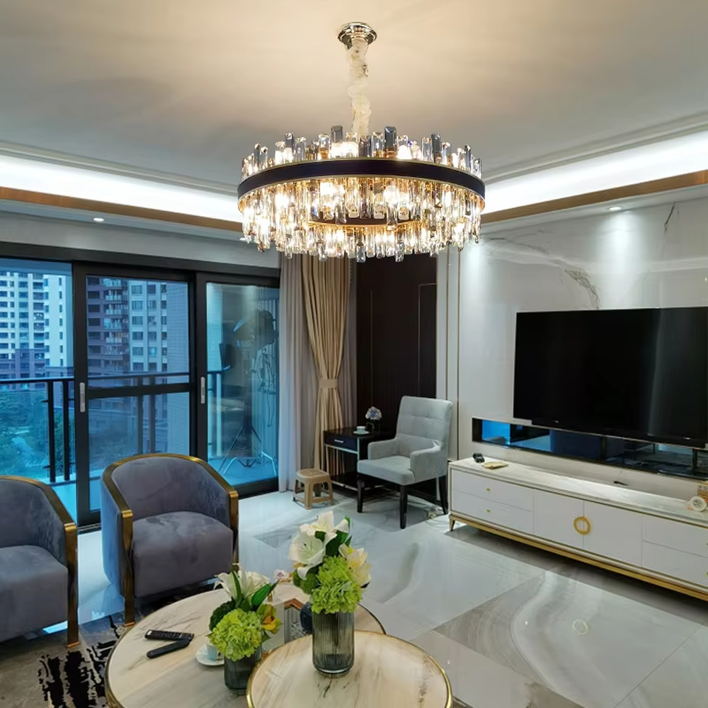 This light luxury black-gold double-layer round crystal chandelier features a black metal frame with crystal strips on the upper layer, and a gold frame with hanging faceted crystals on the lower layer. Light refracts through the crystals to emit a brilliant glow, serving both lighting and decorative purposes, suitable for modern light luxury spaces such as living rooms and dining rooms.