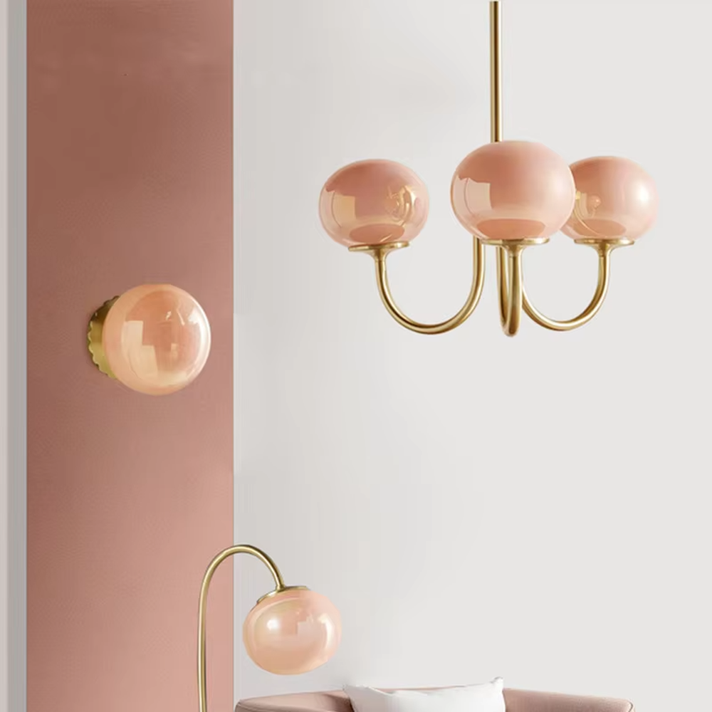 This light luxury pink-gold spherical chandelier features a curved bracket made of gold metal, paired with three pink gradient spherical lampshades, with soft and romantic light, serving both lighting and decorative purposes, suitable for warm spaces such as dining rooms and bedrooms.
