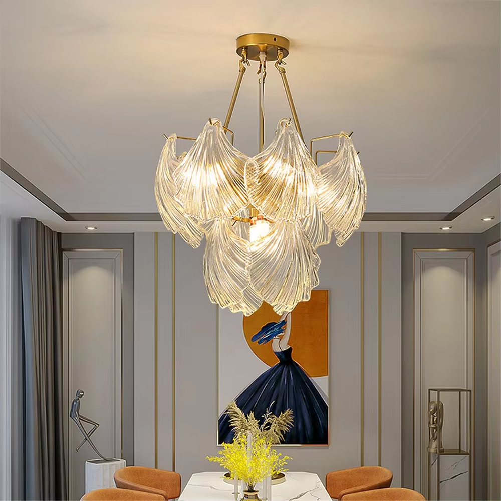A modern light luxury style art chandelier, featuring a gold metal frame paired with multi-layered fan-shaped textured transparent glass panels, shaped like overlapping ginkgo leaves in bloom. It emits a soft and brilliant glow when lit, combining decorative appeal with practical illumination, ideal for creating a romantic and elegant space atmosphere.
