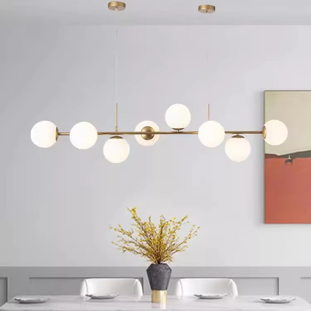 A modern light luxury style linear molecular ball chandelier, featuring a gold metal frame paired with asymmetrically arranged milky white glass glowing spheres. It emits a soft and uniform glow when lit, combining decorative appeal with practical illumination, ideal for creating a minimalist and sophisticated space atmosphere.