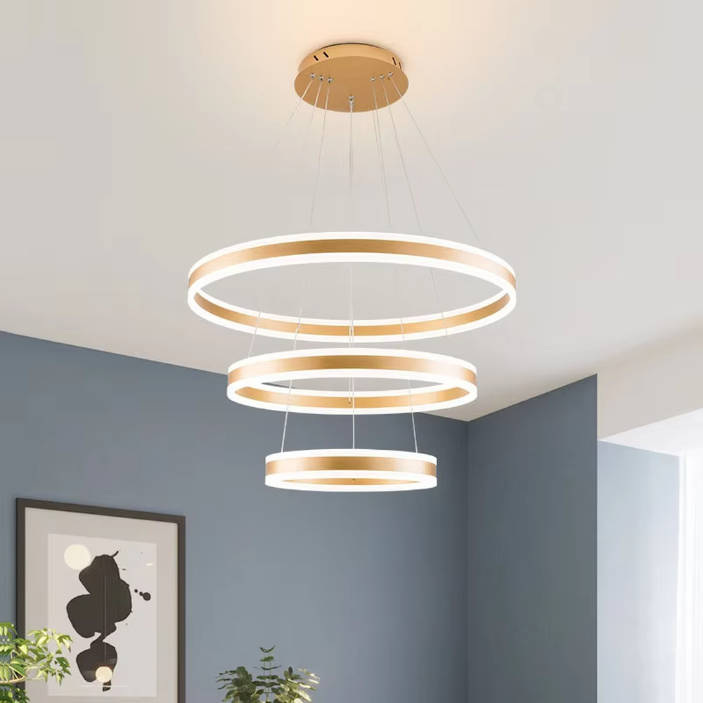 A modern light luxury three-tier ring LED chandelier, featuring a gold metal frame with built-in soft light strips and adjustable suspension rods for different ceiling heights, combining lighting and decorative functions, ideal for creating a minimalist and sophisticated space atmosphere.