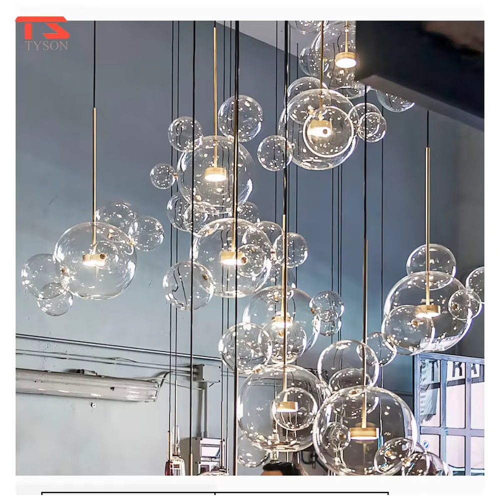 A modern light luxury style bubble-shaped chandelier, suspended by gold wires, paired with transparent glass bubble lampshades of varying sizes. It emits a soft and transparent glow when lit, combining decorative appeal with practical illumination, ideal for creating a dreamy and light space atmosphere.
