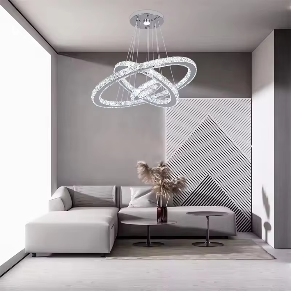 This is a modern light luxury style three-layer ring crystal chandelier, with a silver metal ceiling plate paired with glittering and transparent crystal rings, which has both lighting and decorative functions, suitable for living rooms, dining rooms, villa high-ceiling spaces, etc.