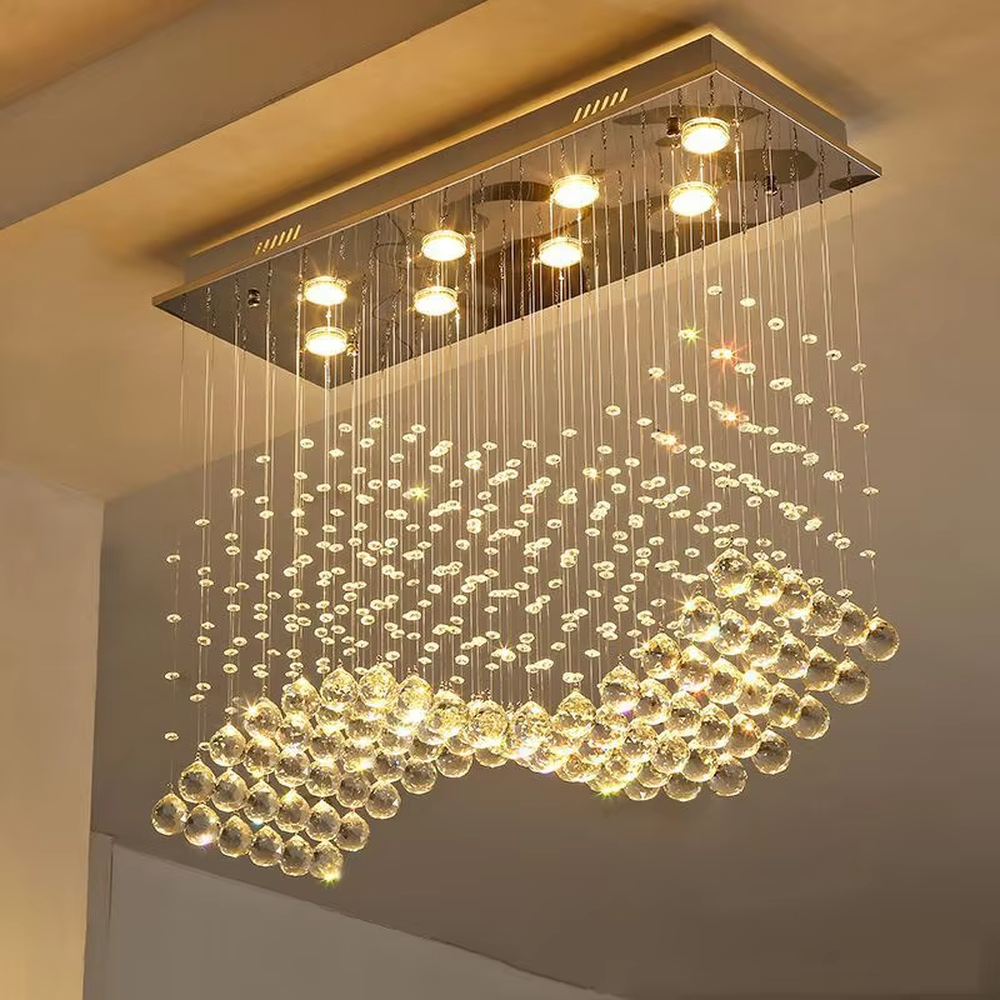 This modern light luxury rectangular crystal ceiling lamp is composed of a large number of hanging crystal bead strings, presenting a layered waterfall shape. The light refracts through the crystal to emit a brilliant and transparent glow, serving both core lighting and decorative purposes, suitable for modern light luxury style spaces such as living rooms and dining rooms.