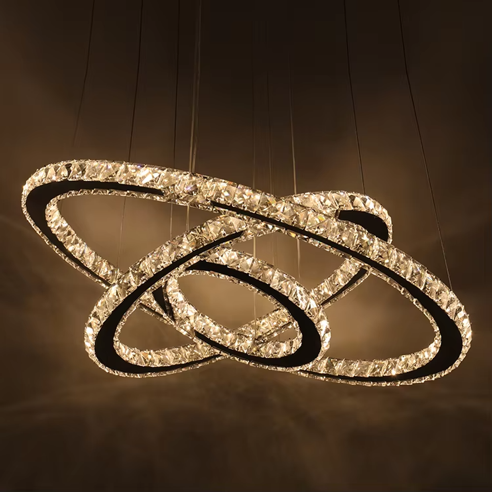 This light luxury black-gold interlaced ring crystal chandelier features a multi-layer flowing ring shape made of metal frames and crystal strips, with light refracting a brilliant halo through the crystals, serving both lighting and decorative purposes, suitable for modern light luxury spaces such as living rooms and dining rooms.