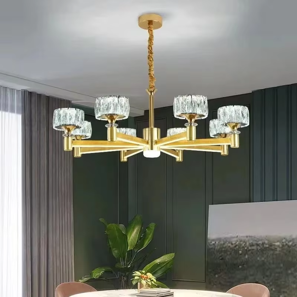 A modern light luxury style multi-head chandelier, featuring a gold metal frame paired with cut-texture crystal glass lampshades, with an additional auxiliary light source in the center. It emits a brilliant and soft glow when lit, combining decorative appeal with practical illumination, ideal for creating an exquisite and high-end space atmosphere.