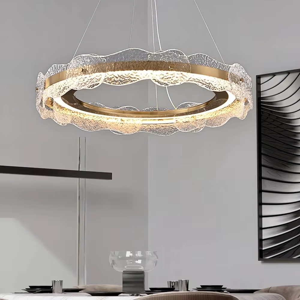 A modern light luxury style double-layer ring chandelier, featuring a gold metal frame paired with transparent glass panels with water ripple texture. It emits a soft and brilliant glow when lit, combining decorative appeal with practical illumination, ideal for creating a high-end and elegant space atmosphere.