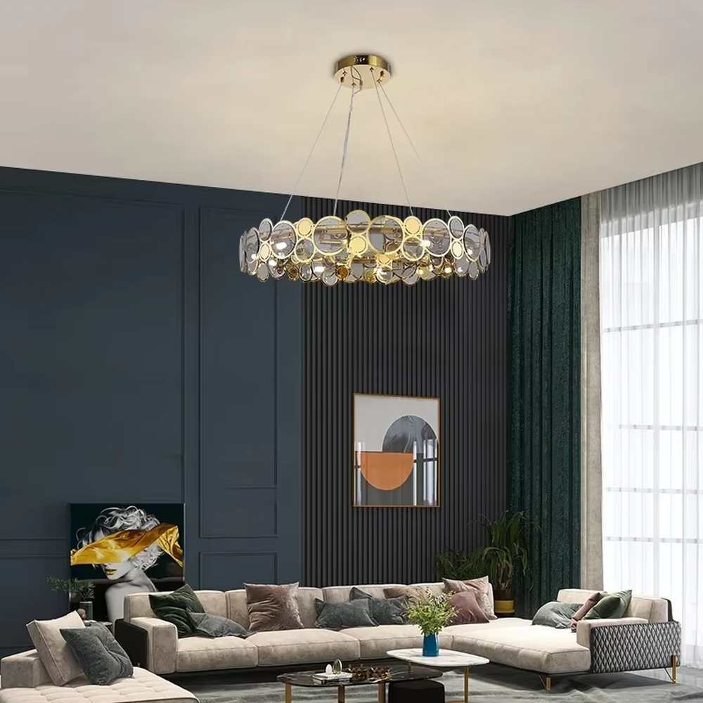 A modern light luxury style linear chandelier, featuring a gold metal frame with interlocked circular transparent glass panels and gold rings. It emits a brilliant yet soft glow when lit, combining decorative appeal with practical illumination, ideal for creating a sophisticated and high-end space atmosphere.
