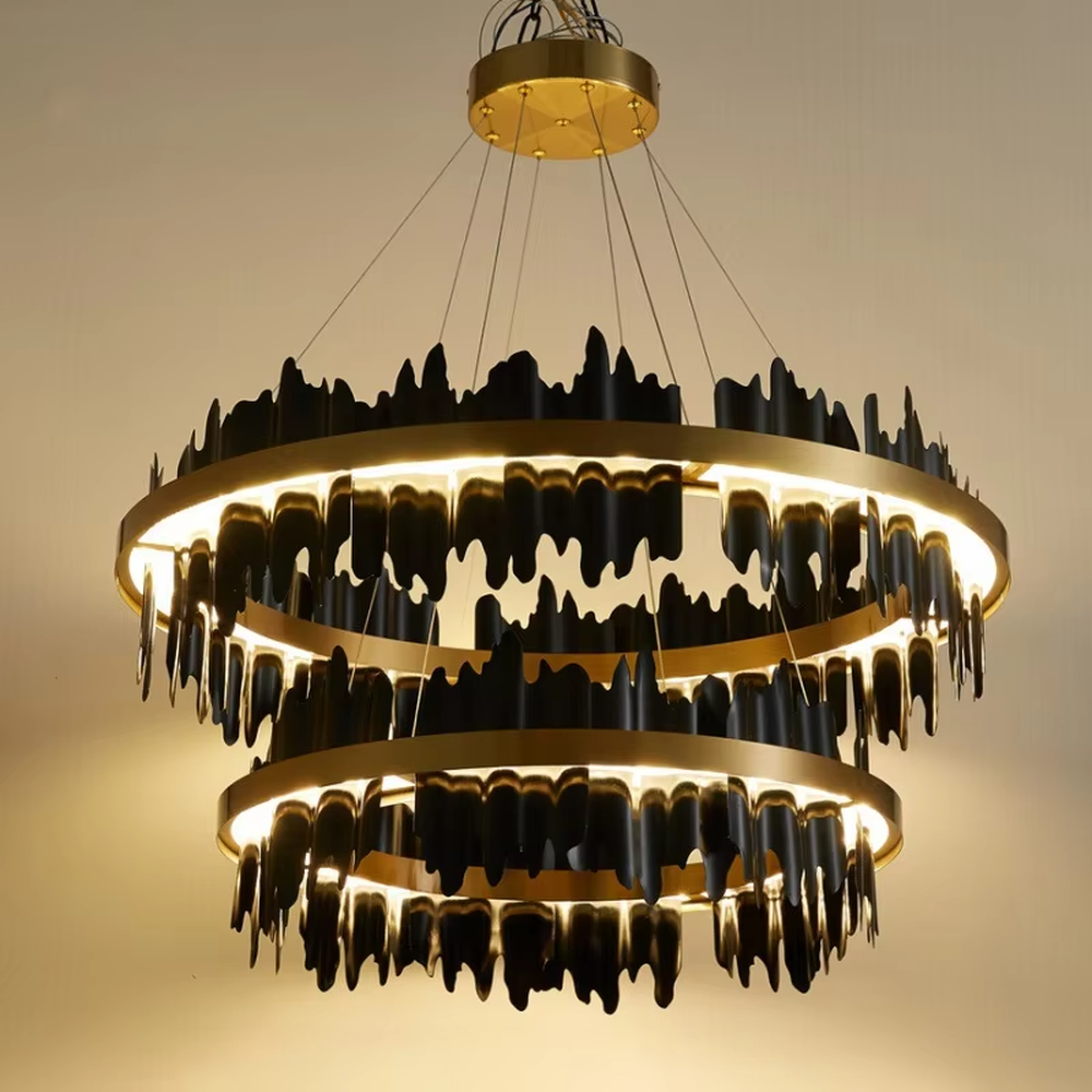 Modern light luxury black and gold ring chandelier, featuring irregular black and gold metal pieces to create a lava-like flowing shape. Light shines through the gaps between the metal rings, combining artistry and ambiance, making it a high-end decorative lighting fixture that elevates the space's style.
