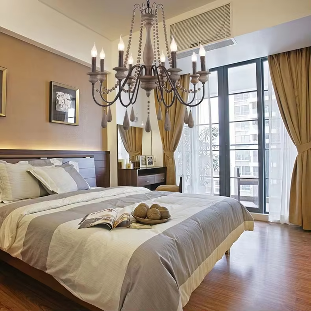 A French country retro style 6-head chandelier, featuring a weathered solid wood main frame paired with iron lamp arms, wooden bead chains and teardrop pendants, using candle-shaped bulbs. It emits a warm and soft glow when lit, combining decorative appeal with practical illumination, ideal for creating a cozy and retro space atmosphere.