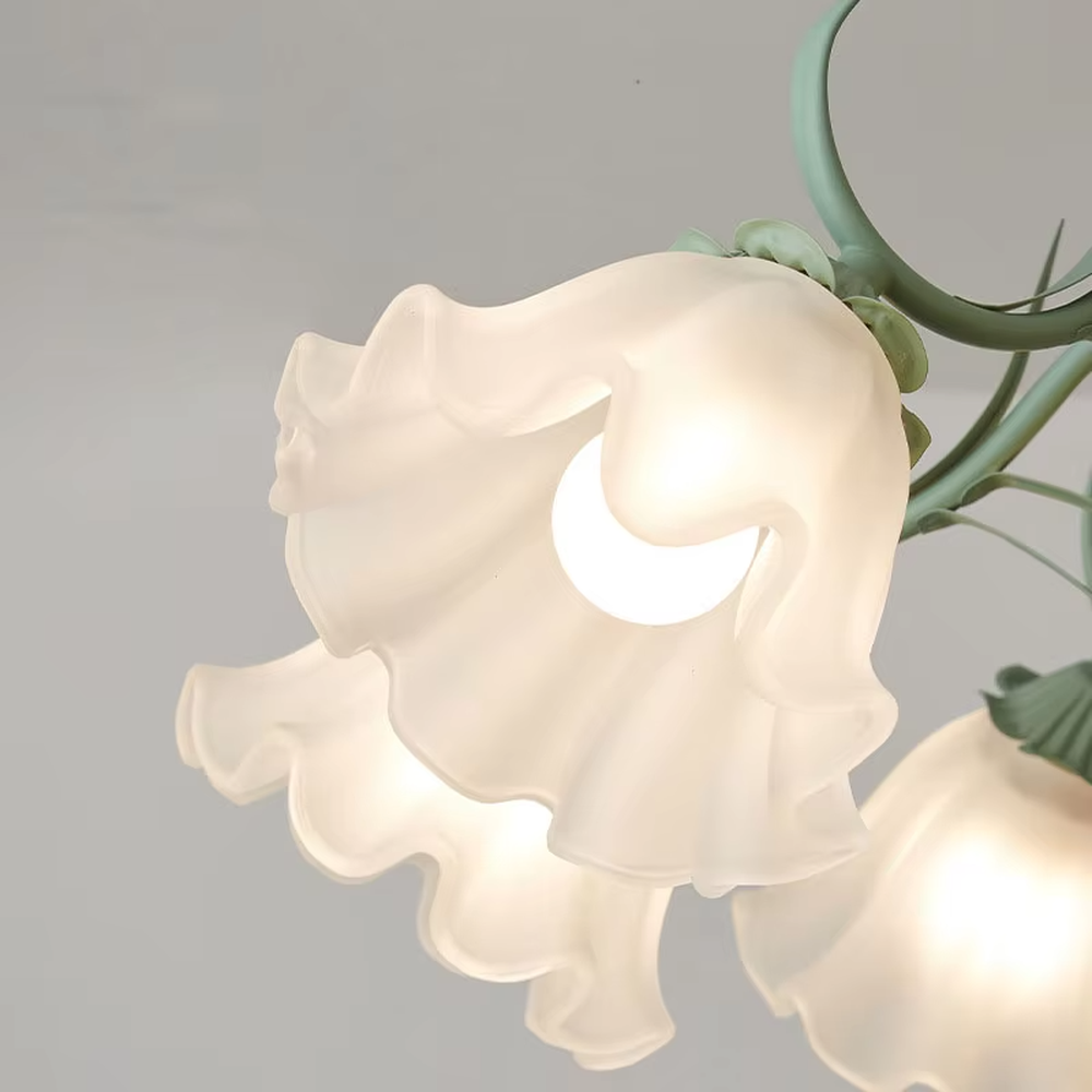 This French pastoral style flower chandelier features a green metal branch paired with white flower-shaped lampshades, with light refracting a soft halo through the frosted lampshades, serving both lighting and decorative purposes, suitable for warm and romantic spaces such as bedrooms and dining rooms.