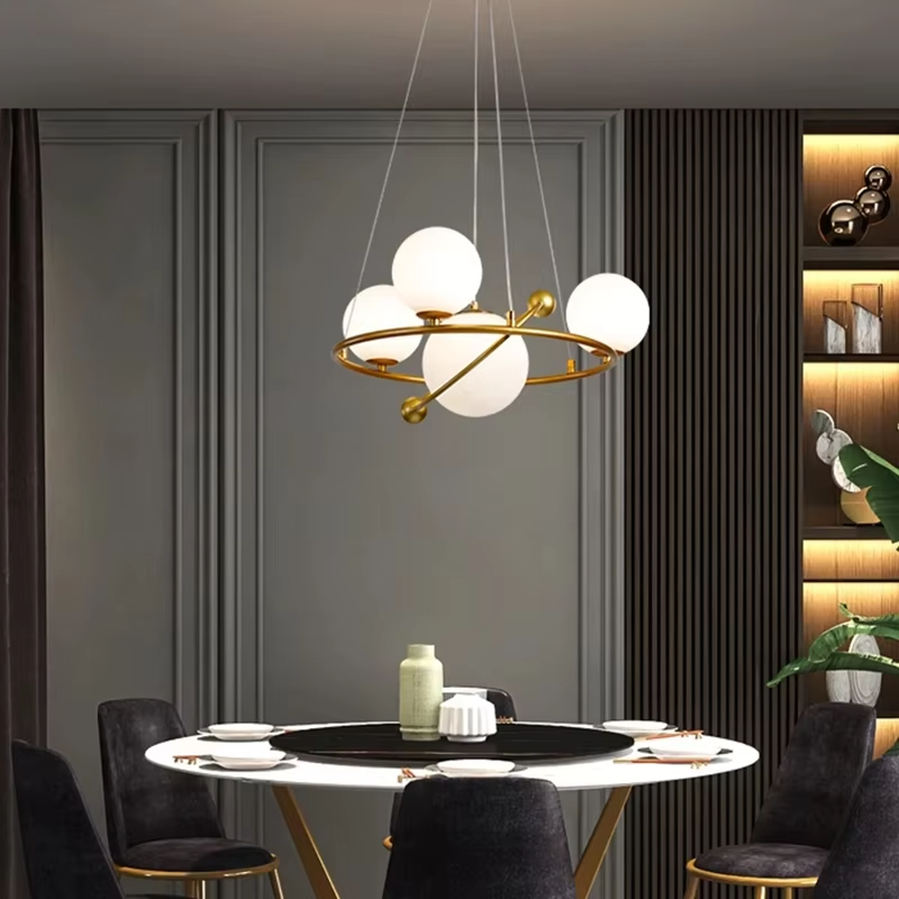 A modern light luxury style planetary orbit chandelier, featuring a gold metal ring frame paired with milky white glass glowing spheres, shaped like planets orbiting a star. It emits a soft and uniform glow when lit, combining decorative appeal with practical illumination, ideal for creating a minimalist and sophisticated space atmosphere.