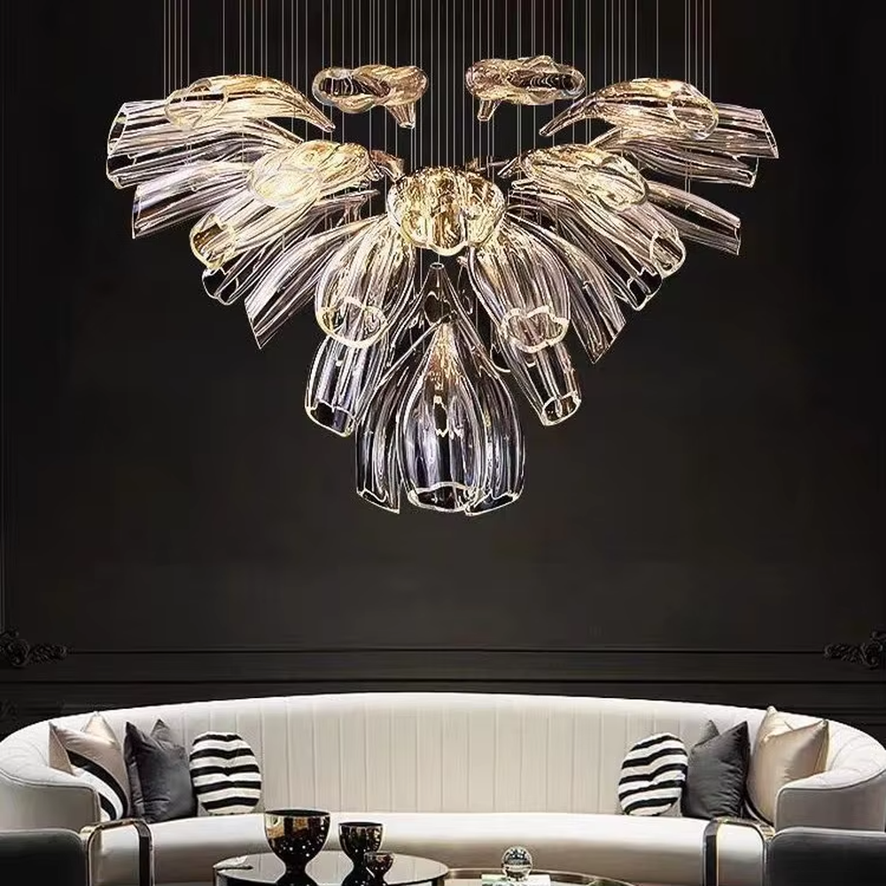 Modern art wing-petal shaped large chandelier, composed of transparent and gold-gradient glass/acrylic leaves in a symmetrical radial hanging structure, emitting transparent and brilliant light, combining artistic decorativeness and lighting function, suitable for core decoration and main lighting in high-ceiling spaces such as villa high-ceiling living rooms, duplex stairwells, and high-end clubs.