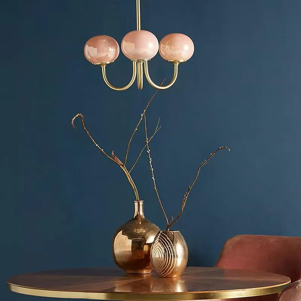 This light luxury pink-gold spherical chandelier features a curved bracket made of gold metal, paired with three pink gradient spherical lampshades, with soft and romantic light, serving both lighting and decorative purposes, suitable for warm spaces such as dining rooms and bedrooms.
