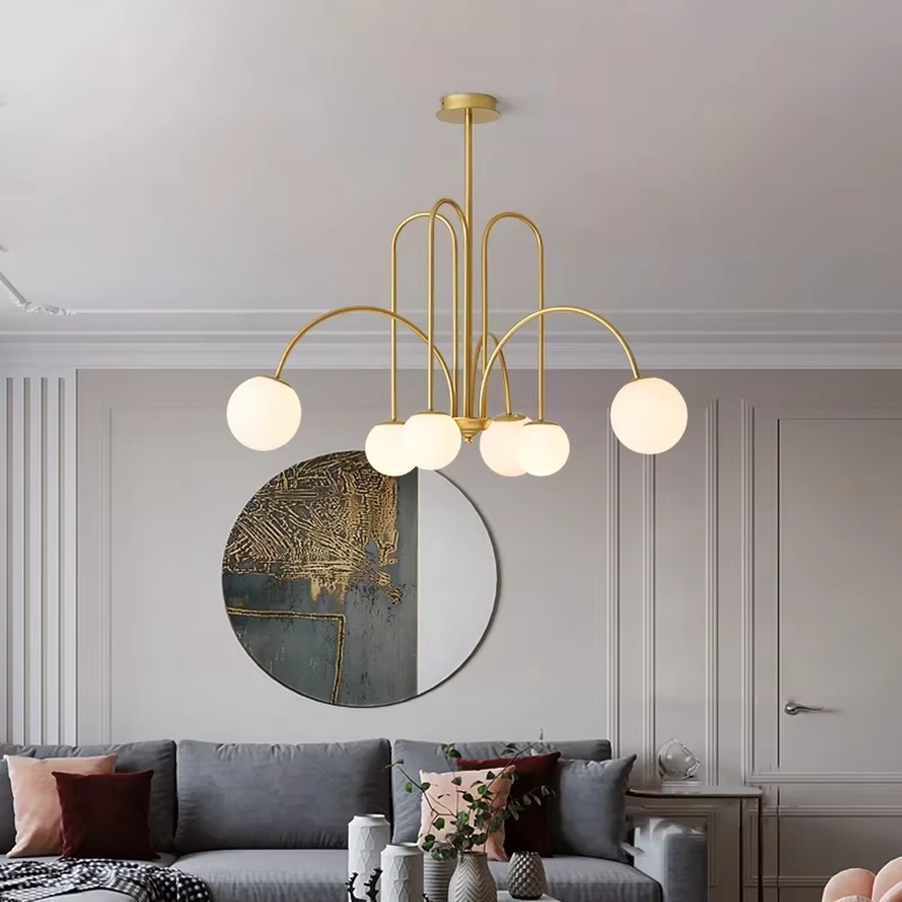 A multi-head chandelier combining modern light luxury and French retro styles, featuring a gold metal curved branch frame paired with milky white glass glowing spheres of varying sizes. It emits soft and uniform warm light when lit, combining decorative appeal with practical illumination, ideal for creating an elegant and dynamic space atmosphere.
