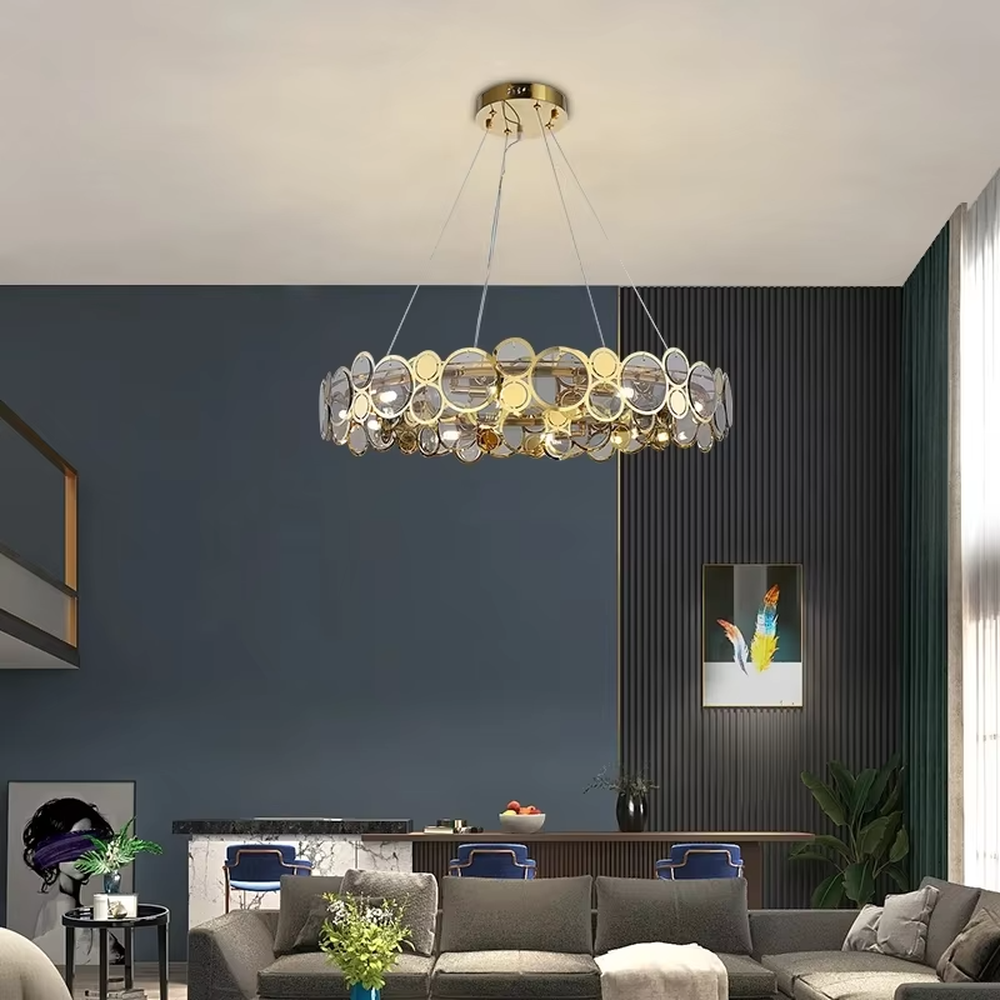A modern light luxury style linear chandelier, featuring a gold metal frame with interlocked circular transparent glass panels and gold rings. It emits a brilliant yet soft glow when lit, combining decorative appeal with practical illumination, ideal for creating a sophisticated and high-end space atmosphere.