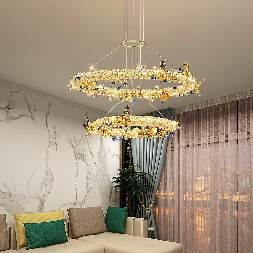 A light luxury and glamorous three-tiered ring chandelier, decorated with crystal gravel, natural blue-veined stone, and gold metal butterflies. Its staggered ring structure resembles flowing cosmic orbits, emitting a brilliant yet soft glow when lit, combining artistic decoration with lighting functionality, ideal for creating a high-end and romantic space atmosphere.