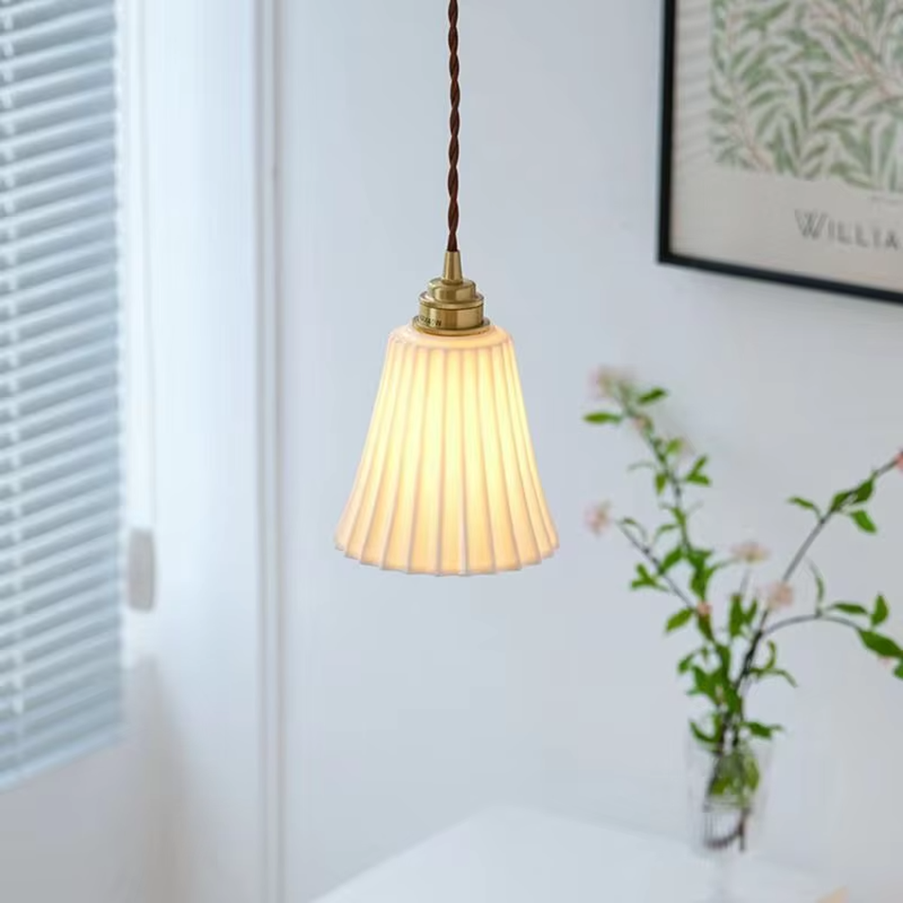 A French retro light luxury style 3-head chandelier, featuring a brass-colored metal frame paired with pleated fabric lampshades. It emits a soft and warm glow when lit, combining decorative appeal with practical illumination, ideal for creating an elegant and romantic space atmosphere.