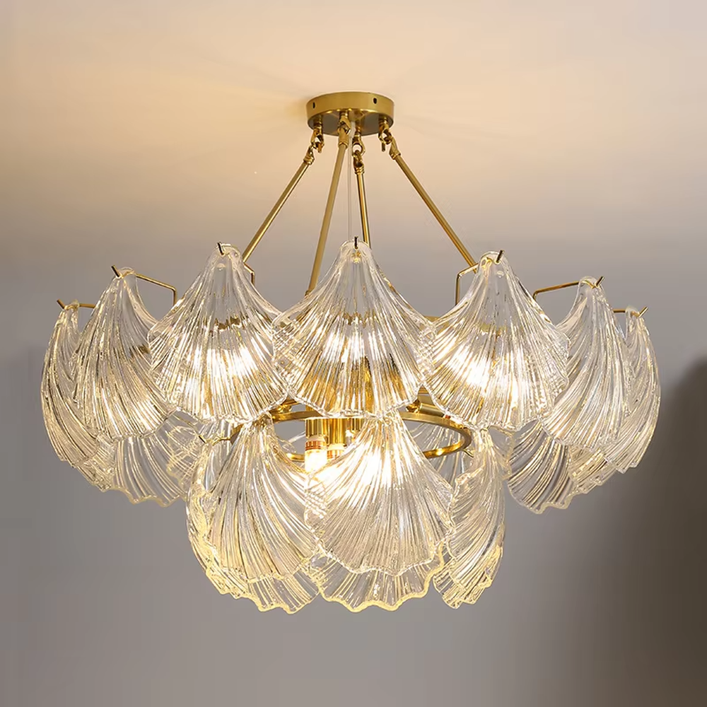 A modern light luxury style art chandelier, featuring a gold metal frame paired with multi-layered fan-shaped textured transparent glass panels, shaped like overlapping ginkgo leaves in bloom. It emits a soft and brilliant glow when lit, combining decorative appeal with practical illumination, ideal for creating a romantic and elegant space atmosphere.
