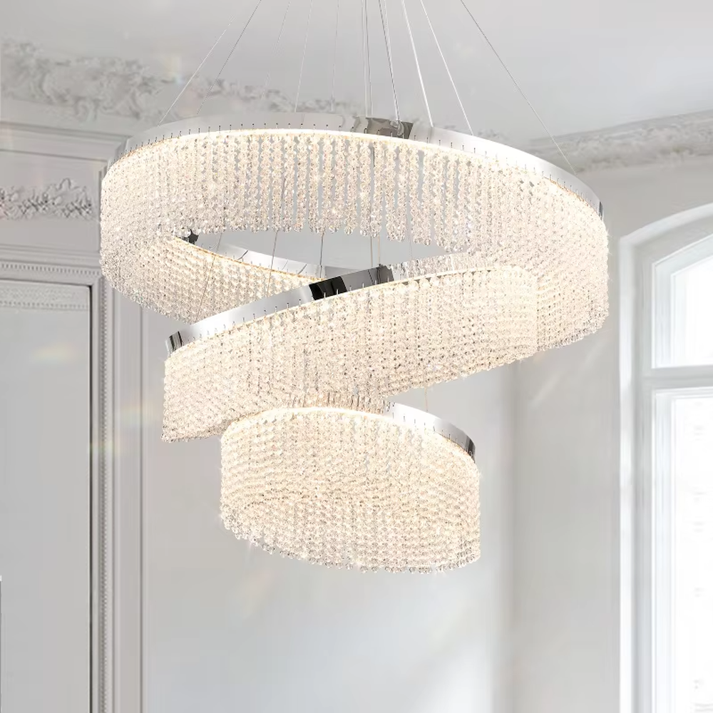 Modern light luxury three-layer spiral ring crystal chandelier, composed of dense crystal particles and silver metal frames in a staggered spiral structure, emitting brilliant and soft light, combining artistic decorativeness and lighting function, suitable for core lighting and atmosphere creation in living rooms, dining rooms, villa high-ceiling spaces, etc.