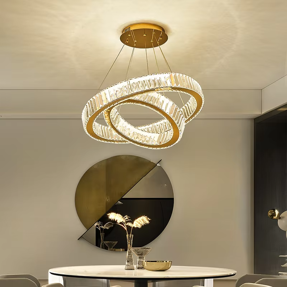 This is a light luxury three-ring interlaced crystal chandelier, with a gold metal frame inlaid with high-transparency crystal strips, presenting a dynamic ring interlaced shape, with brilliant and soft light, both decorative and lighting functions, ideal for high-end indoor spaces such as dining rooms and living rooms.