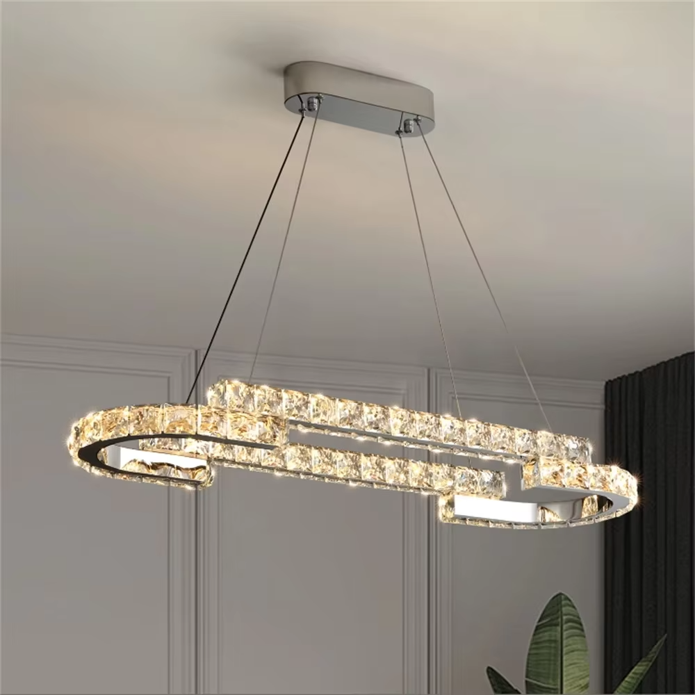 This modern light luxury double-ring interwoven crystal chandelier features a silver metal base, inlaid with transparent crystals to create a dynamic double-ring interwoven shape. When lit, light refracts through the crystal to emit a brilliant and dynamic glow, combining a futuristic feel with an ambient atmosphere. Ideal for living rooms, dining rooms, light luxury apartments, and other spaces, it adds an exquisite and sophisticated touch to modern minimalist or light luxury home environments.
