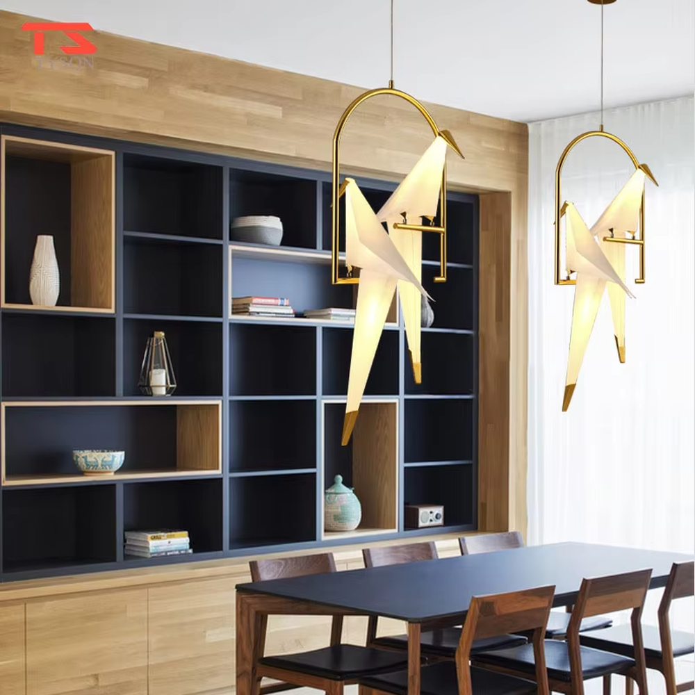 Modern art origami crane cage chandelier, featuring an arched gold metal frame paired with a white origami crane lampshade made with paper folding techniques. Its elegant and dynamic lines combine artistry and ambiance, making it a decorative lighting fixture that elevates the space's style.