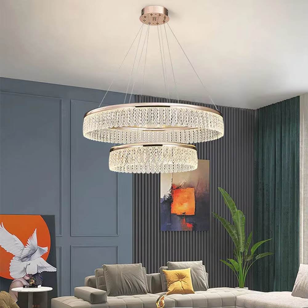 Modern light luxury double-layer ring crystal chandelier, featuring a rose gold metal frame paired with dense crystal strips to create a double-layer suspended shape. Light refracts through the crystals to produce a brilliant and soft glow, combining sophistication and ambiance, making it a high-end decorative lighting fixture that elevates the space's style.