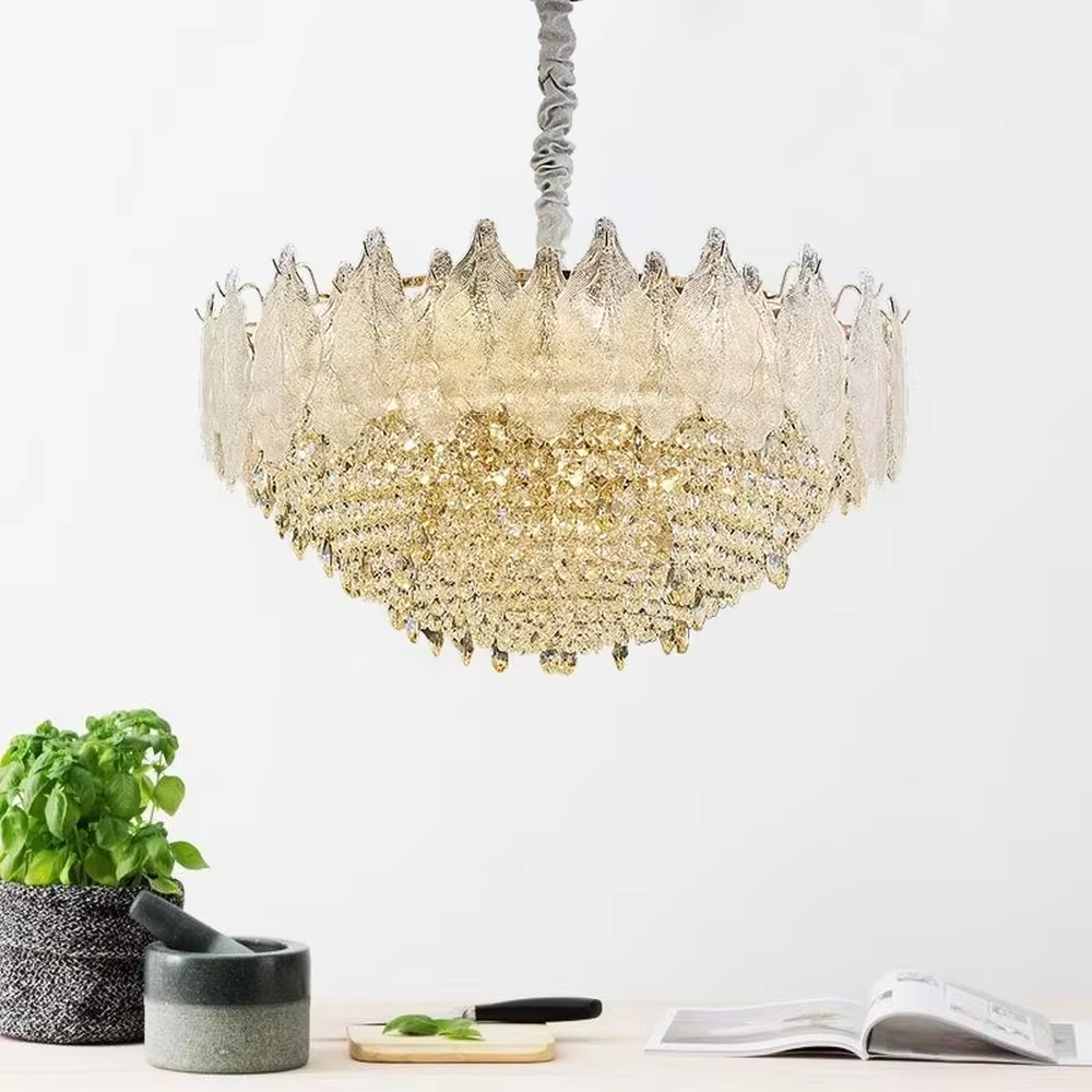 This modern light luxury two-layer chandelier features an upper layer of transparent leaf-textured glass lampshades and a lower layer of dense crystal tassels, forming a full flower crown shape. When lit, light refracts through the crystal and glass to emit a brilliant and soft glow, combining an ethereal texture with an ambient atmosphere. Ideal for living rooms, dining rooms, light luxury apartments, and other spaces, it adds a dreamy and exquisite touch to modern minimalist or French light luxury home environments.