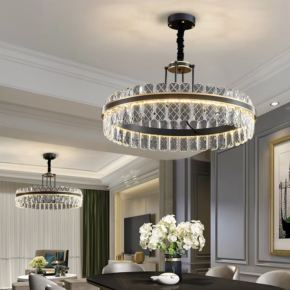 This modern light luxury two-layer circular crystal chandelier features a black metal frame, inlaid with transparent crystal strips with diamond textures to form a double-layered circular shape, paired with a height-adjustable black suspension rod. When lit, light refracts through the crystal to emit a brilliant and luxurious glow, combining a bold texture with an ambient atmosphere. Ideal for living rooms, dining rooms, light luxury apartments, and other spaces, it adds an exquisite and sophisticated touch to modern minimalist or industrial-style home environments.