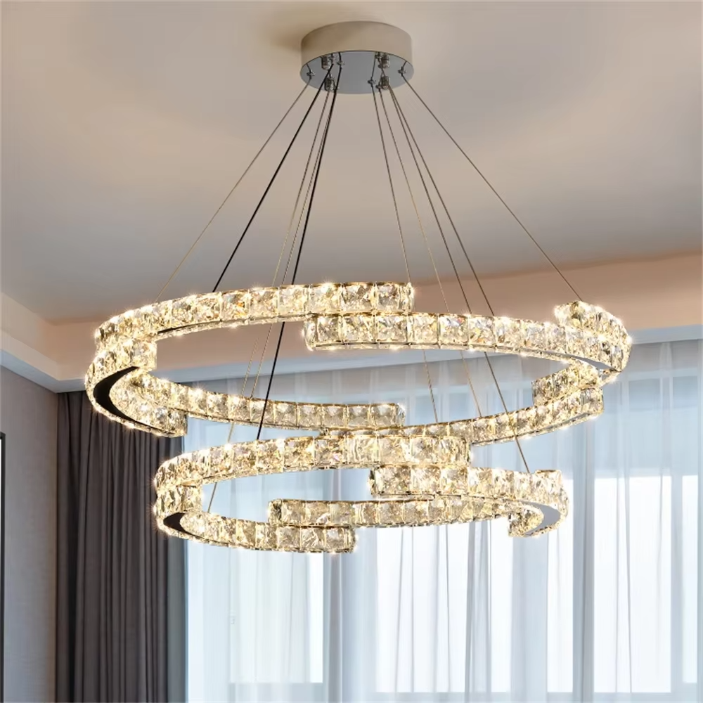 This modern light luxury double-ring interwoven crystal chandelier features a silver metal base, inlaid with transparent crystals to create a dynamic double-ring interwoven shape. When lit, light refracts through the crystal to emit a brilliant and dynamic glow, combining a futuristic feel with an ambient atmosphere. Ideal for living rooms, dining rooms, light luxury apartments, and other spaces, it adds an exquisite and sophisticated touch to modern minimalist or light luxury home environments.
