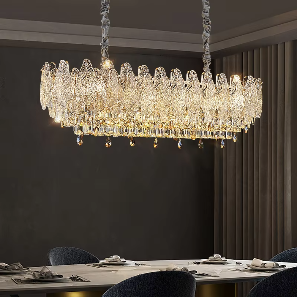 This modern light luxury linear crystal chandelier features a wavy upper lampshade made of transparent textured crystal slices, with dense crystal tassels hanging below, suspended by braided cords. When lit, light refracts through the crystal to emit a brilliant and soft glow, combining an ethereal texture with an ambient atmosphere. Ideal for dining rooms, bars, light luxury apartments, and other spaces, it adds a dreamy and exquisite touch to modern minimalist or French light luxury home environments.