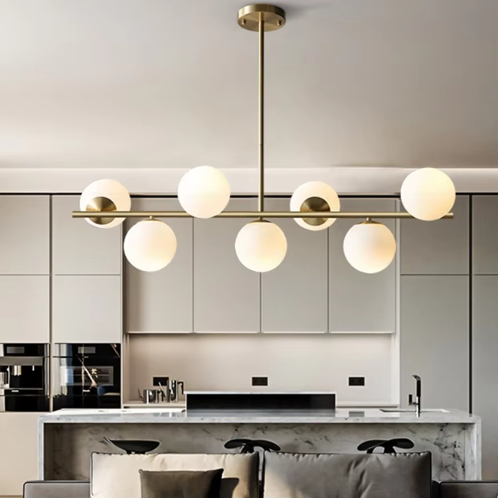 This modern minimalist linear magic bean chandelier features a gold metal frame and multiple milky white frosted glass ball lampshades, arranged in a staggered layout. When lit, it emits soft and even light, combining minimalist design with a gentle ambient atmosphere. Ideal for dining rooms, bars, kitchen islands, and other spaces, it adds an exquisite and soft touch to modern minimalist or Nordic-style home environments.