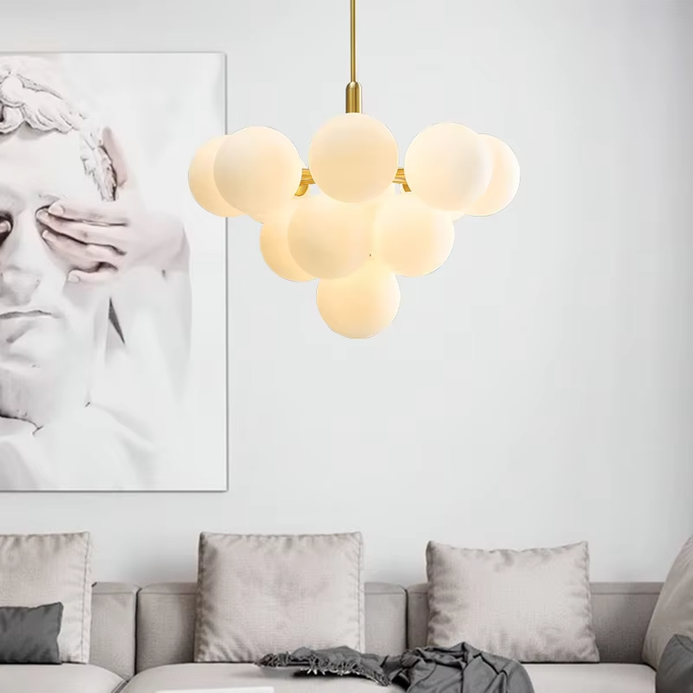 Modern healing cloud magic bean chandelier, featuring a brass metal frame paired with fluffy milk-white frosted glass balls to form a cloud shape. It emits soft and gentle light, combining a dreamy feel and cozy ambiance, making it a decorative lighting fixture that enhances the warmth of the space.