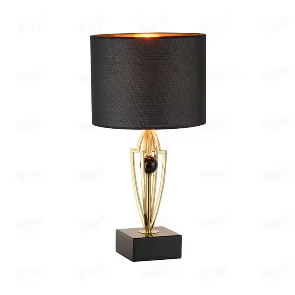 This is a luxurious retro-style table lamp with a golden metal bracket, a black square base, and a black fabric lampshade. It features a grand and elegant design with artistic texture. It is used for local desktop lighting and decoration, creating a luxurious retro ambiance. It is suitable for luxury-style home bedrooms, high-end hotel guest rooms, art exhibition halls and other places.