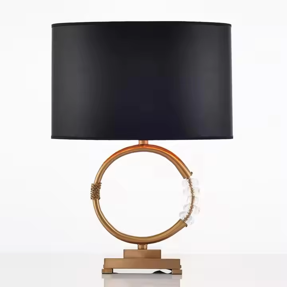 This is a luxurious retro-style table lamp with a golden circular base, a black fabric lampshade, and crystal elements, featuring an elegant and grand design. It is used for local desktop lighting and decoration, enhancing the luxurious retro ambiance of the space. It is suitable for luxury-style home living room side tables, high-end hotel guest rooms, retro-style clubs and other places.