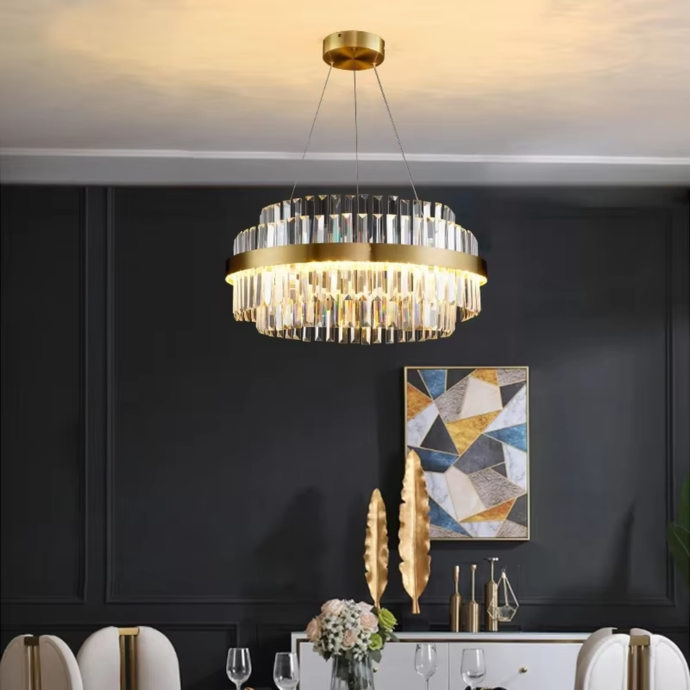 This modern light luxury two-layer circular crystal chandelier features a gold metal frame, with dense transparent long crystals hanging down to form a full circular shape. When lit, light refracts through the crystal to emit a brilliant and soft glow, combining a luxurious texture with an ambient atmosphere. Ideal for dining rooms, living rooms, light luxury apartments, and other spaces, it adds an exquisite and sophisticated touch to modern minimalist or light luxury home environments.