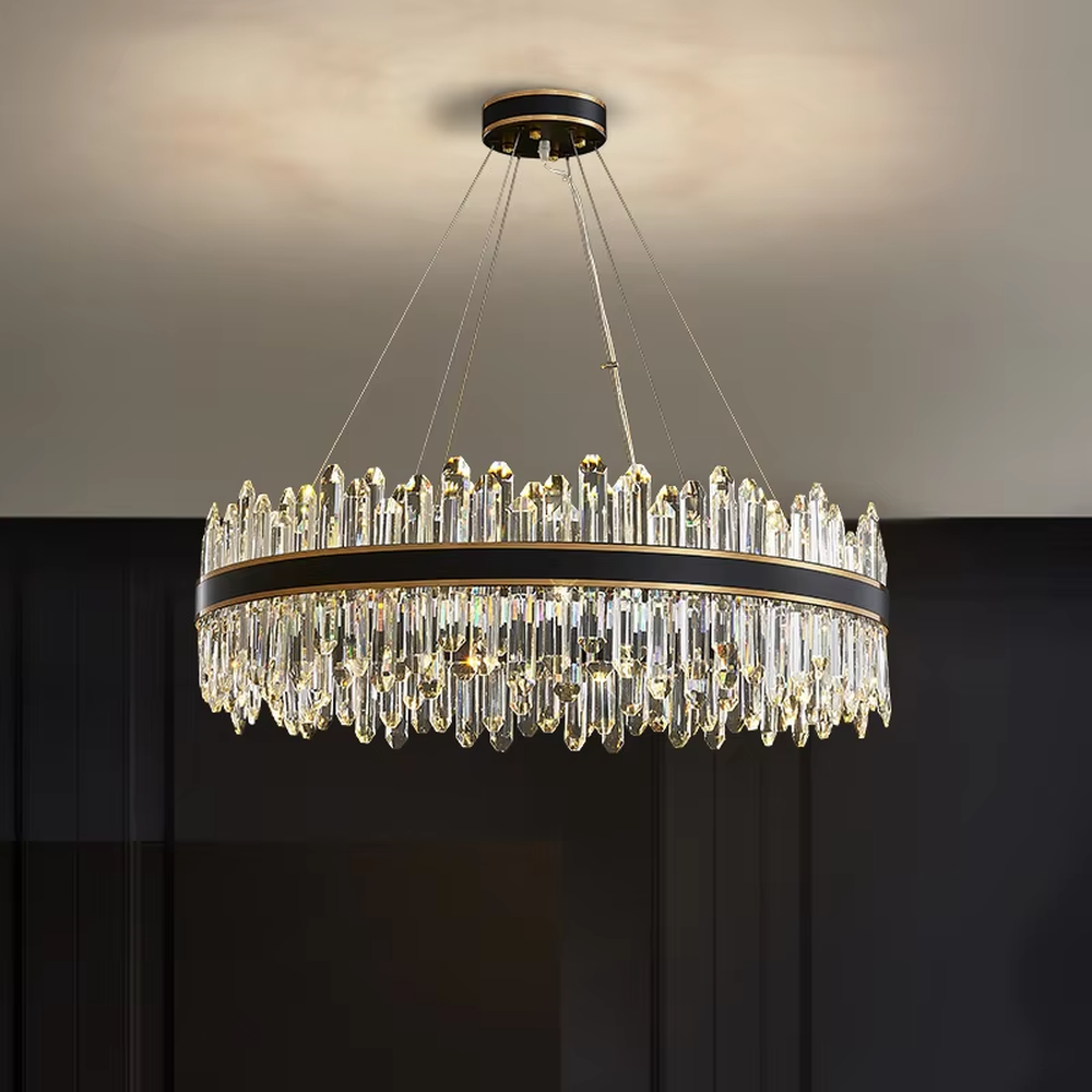This modern light luxury two-layer circular crystal chandelier features a black-gold metal frame, with dense transparent long crystals hanging down to form a full circular shape. When lit, light refracts through the crystal to emit a brilliant and luxurious glow, combining a bold texture with an ambient atmosphere. Ideal for living rooms, dining rooms, light luxury apartments, and other spaces, it adds an exquisite and sophisticated touch to modern minimalist or light luxury home environments.