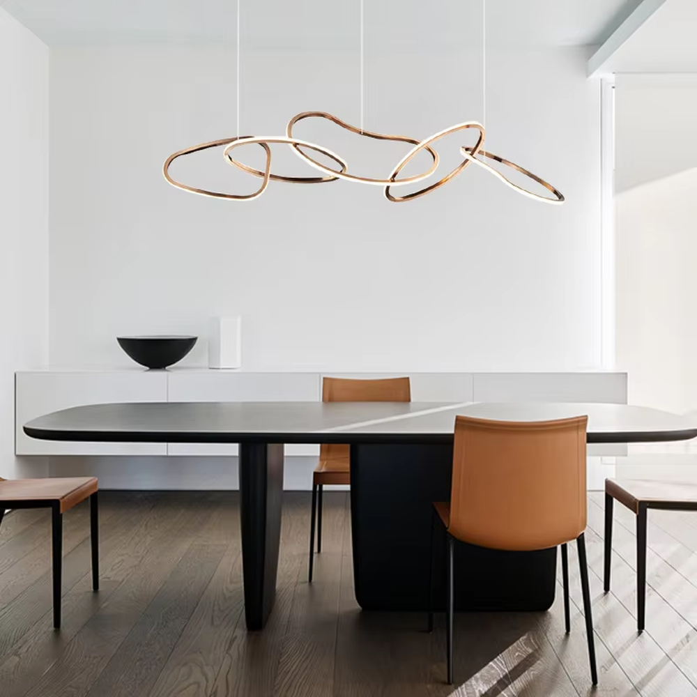 Modern light luxury flowing ring chandelier, featuring interwoven and irregular gold metal rings with built-in soft LED lighting. Its dynamic and elegant lines combine artistry and ambiance, making it a high-end decorative lighting fixture that elevates the space's style.