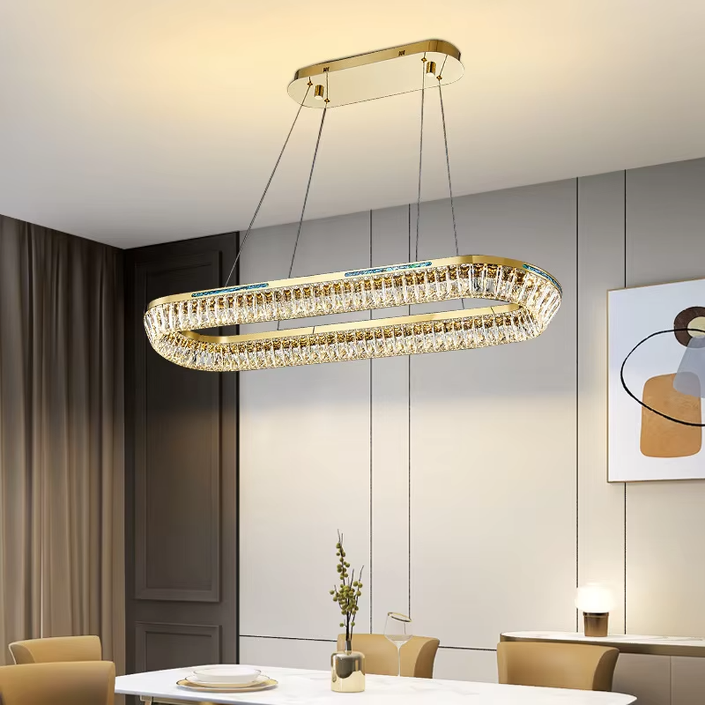 This modern light luxury rectangular two-layer crystal chandelier features a gold metal frame, inlaid with transparent long crystals to form a double-layered rectangular shape. When lit, light refracts through the crystal to emit a brilliant and soft glow, combining an exquisite texture with an ambient atmosphere. Ideal for dining rooms, bars, and above dining tables in light luxury apartments, it adds an exquisite and sophisticated touch to modern minimalist or light luxury spaces.