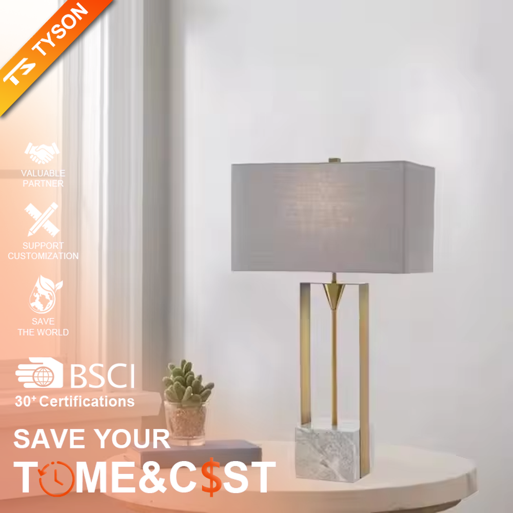 This is a modern minimalist table lamp with a golden metal frame, a marble base, and a gray fabric square lampshade, featuring a simple and elegant design. It is used for local desktop lighting and decoration, combining practicality and aesthetics. It is suitable for modern home living room side tables, bedroom bedside tables, high-end hotel guest rooms, luxury office spaces and other places.