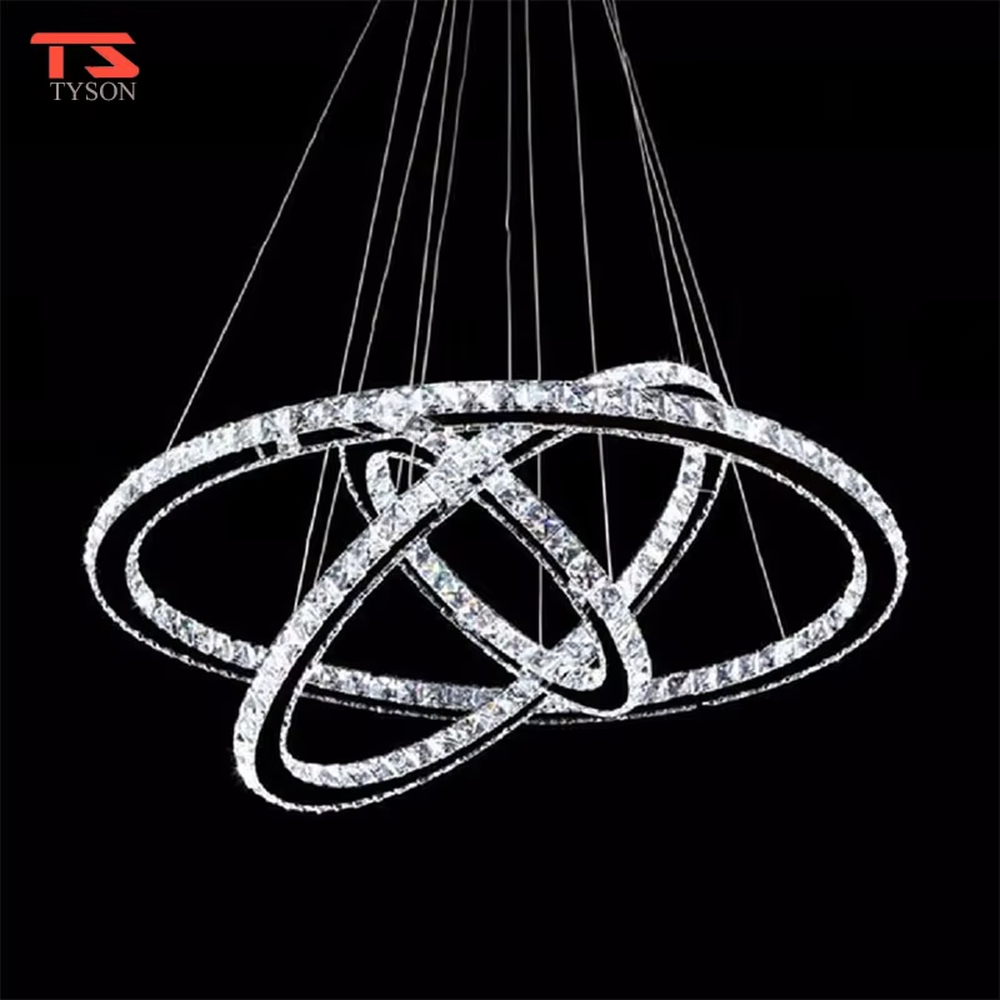 This modern light luxury interwoven ring crystal chandelier consists of transparent crystal rings of varying sizes interlaced and nested, suspended by silver cords. When lit, light refracts through the crystal to emit a brilliant and dynamic glow, combining a futuristic feel with an ambient atmosphere. Ideal for high-ceiling living rooms, villa foyers, light luxury apartments, and other spaces, it adds an exquisite and sophisticated touch to modern minimalist or light luxury environments.