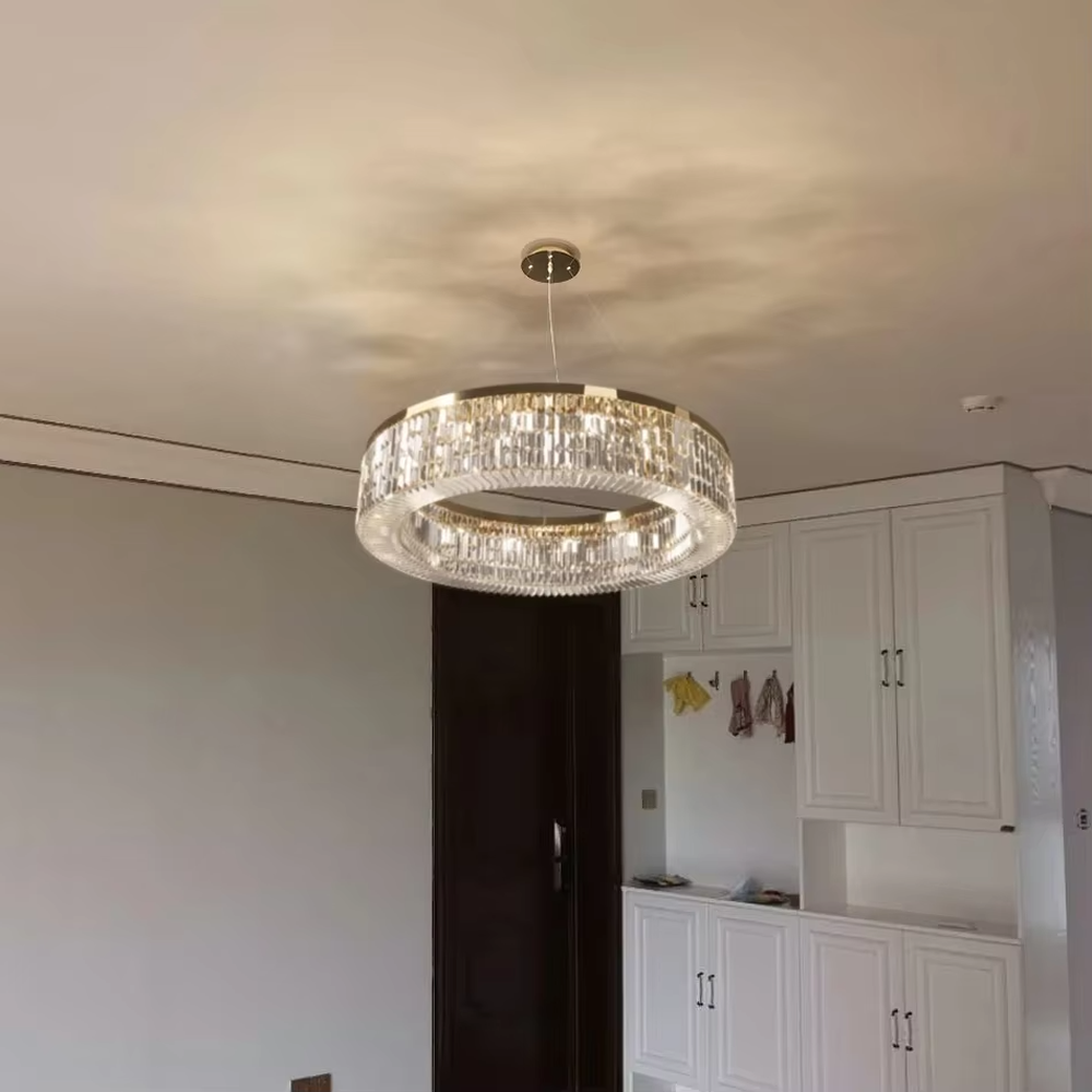 This modern light luxury two-layer circular crystal chandelier features a gold metal frame, inlaid with transparent long crystals to form a double-layered circular shape. When lit, light refracts through the crystal to emit a brilliant and soft glow, combining an exquisite texture with an ambient atmosphere. Ideal for living rooms, dining rooms, light luxury apartments, and other spaces, it adds an exquisite and sophisticated touch to modern minimalist or light luxury home environments.