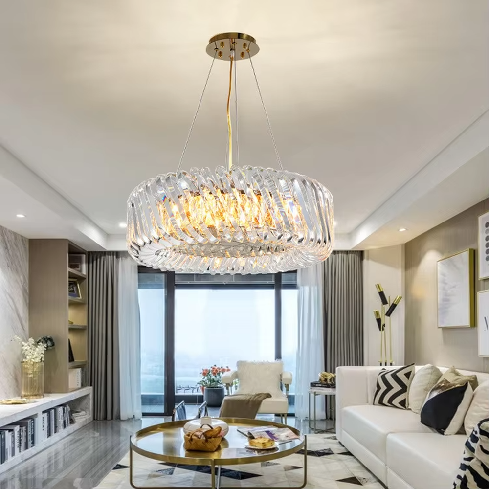 This modern light luxury linear crystal chandelier features a gold metal ceiling base, enclosed by wavy transparent crystal strips to form a full linear shape. When lit, light refracts through the crystal to emit a brilliant and soft glow, combining a transparent texture with an ambient atmosphere. Ideal for dining rooms, bars, light luxury apartments, and other spaces, it adds an exquisite and sophisticated touch to modern minimalist or light luxury home environments.