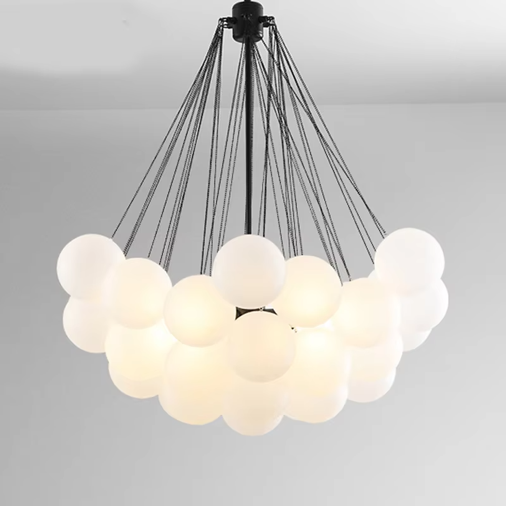 Modern healing cloud chandelier, featuring a radial suspension wire structure in black metal paired with fluffy milk-white frosted glass balls to form a cloud shape. It emits soft and gentle light, combining a dreamy feel and cozy ambiance, making it a decorative lighting fixture that enhances the warmth of the space.