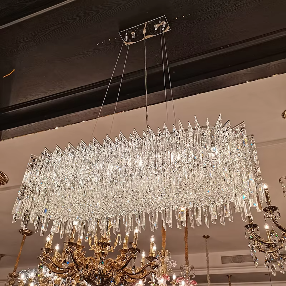This modern light luxury square crystal chandelier features a silver metal frame, with dense transparent long crystals hanging down to form a square shape. When lit, light refracts through the crystal to emit a brilliant and soft glow, combining an exquisite texture with an ambient atmosphere. Ideal for bedrooms, dining rooms, light luxury apartments, and other spaces, it adds an exquisite and sophisticated touch to modern minimalist or light luxury home environments.