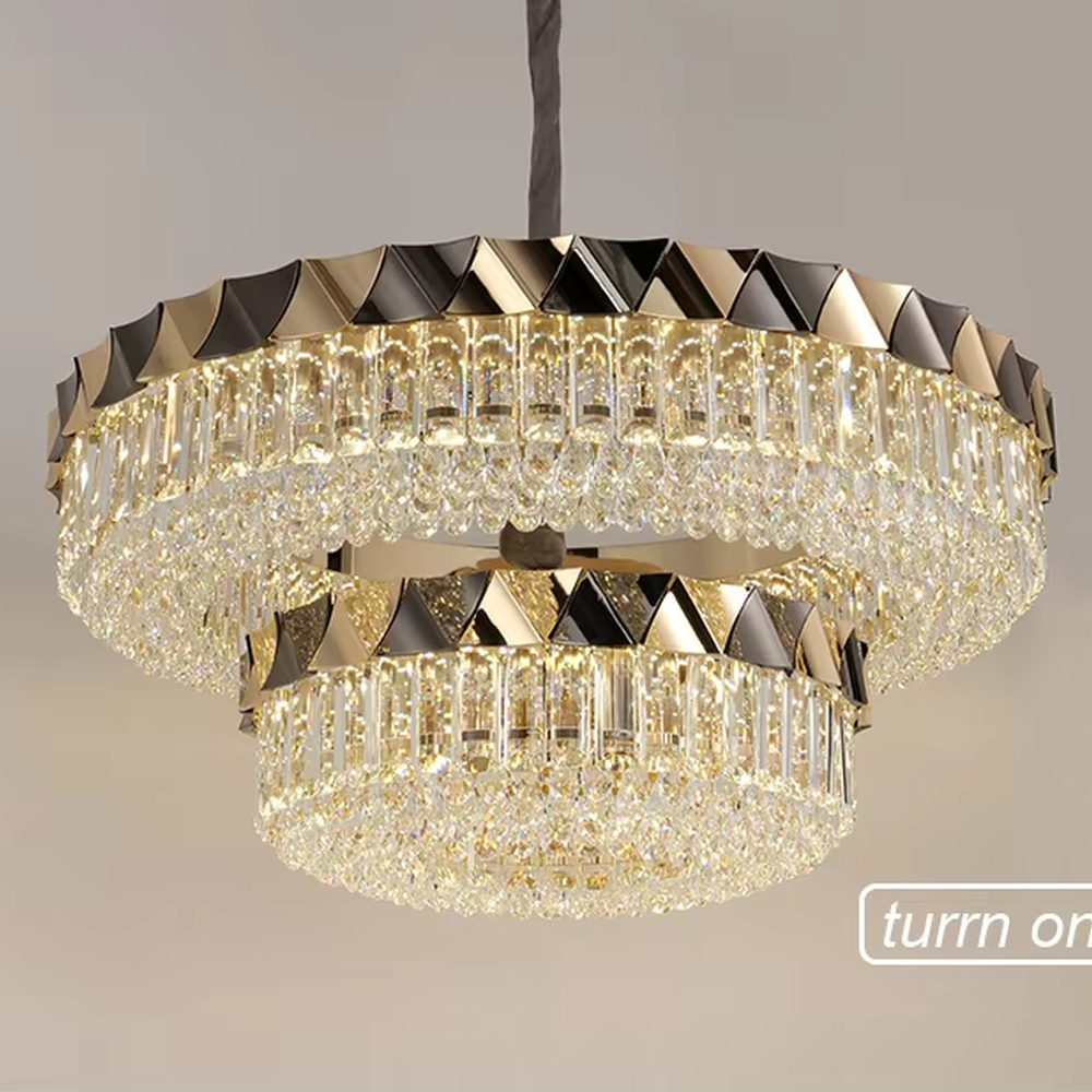 This modern light luxury two-layer circular crystal chandelier features a black-and-gold metal frame, inlaid with transparent long crystals to form a double-layered dome shape. The geometric black-and-gold metal contrasts brilliantly with the shimmering crystal, and when lit, light refracts through the crystal to emit a luxurious and soft glow, combining a sophisticated texture with an ambient atmosphere. Ideal for living rooms, dining rooms, light luxury apartments, and other spaces, it adds an exquisite and luxurious touch to modern minimalist or light luxury home environments.