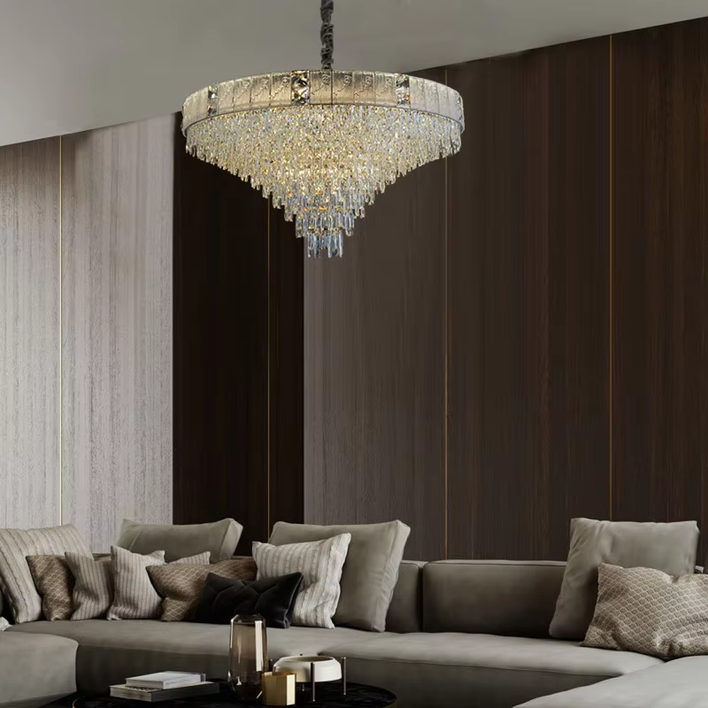 This light luxury and grand two-layer crystal chandelier features a gold metal frame with vertical-textured glass lampshades on the upper layer, and multiple layers of transparent crystal tassels hanging below, creating a full dome shape. When lit, light refracts through the crystal to emit a brilliant and soft glow, combining elegant texture with an ambient atmosphere. Ideal for bedrooms, living rooms, dining rooms, and other spaces, it adds an elegant and exquisite touch to European light luxury or modern minimalist home environments.
